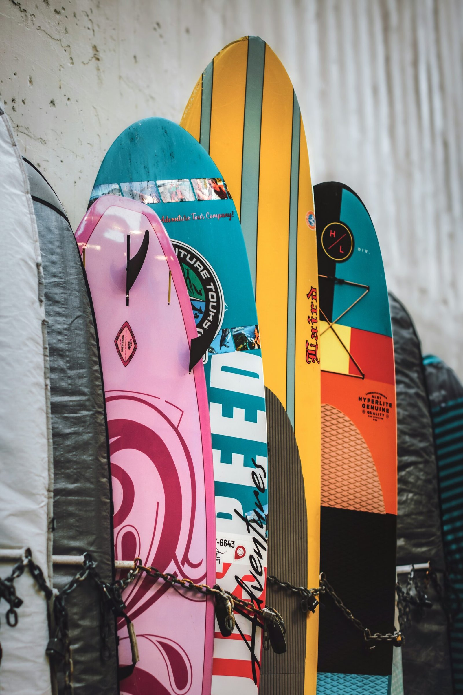 a bunch of surfboards are lined up against a wall